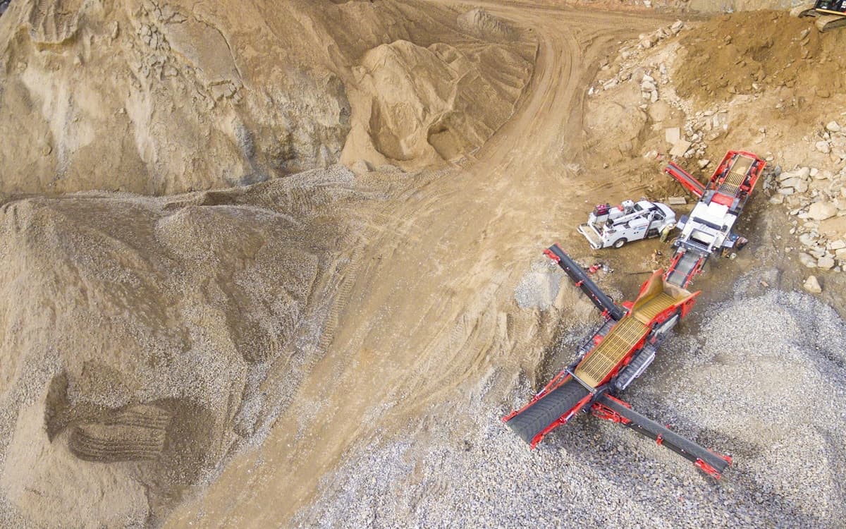 Aerial drone view of quarry crushing equipment and aggregate stockpiles